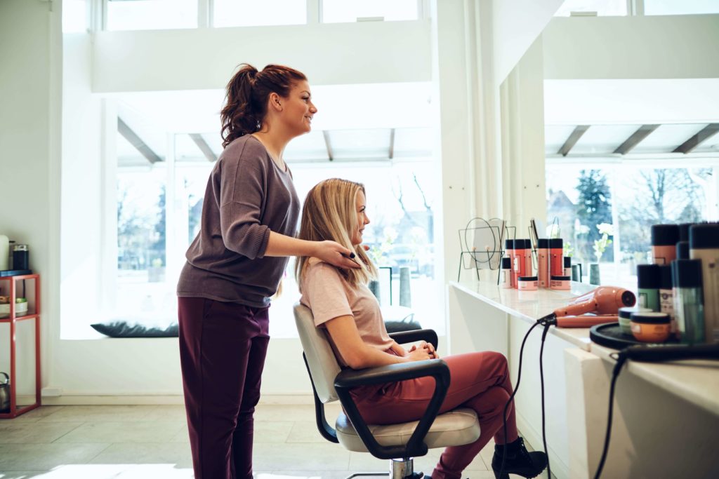 Moderner Friseursalon mit Kunden, die verschiedene Haarschnitte in entspannter Atmosphäre erhalten.